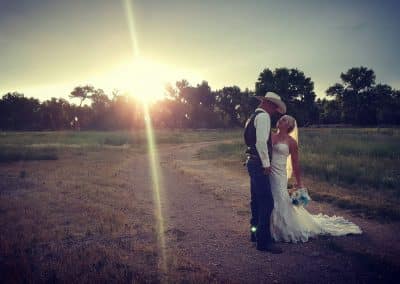 Bride and groom in a field at dusk