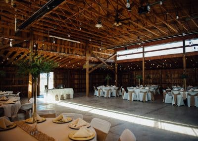 Inside of event barn with tables set for a wedding