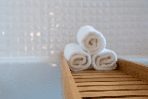 Three hotel towels on a bench