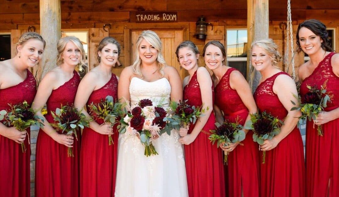 Wedding bride in white dress and bridesmaids wearing red dresses